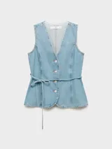 Chaleco de denim con cuello en V, cierre frontal con botones y lazo ajustable en la cintura. Presenta un diseño entallado con costuras verticales y bajo redondeado.