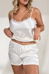 Conjunto de satén color blanco, compuesto por un top con breteles finos y detalles de puntilla en el escote, y un short con cintura elástica.