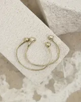 Brazalete rígido abierto de metal color plateado, con terminaciones en forma de herradura.