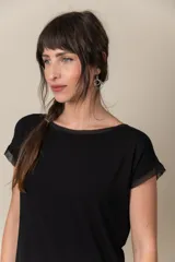 Remera de viscosa y algodón en color negro, con terminaciones de gasa en el cuello, las mangas cortas y el ruedo.