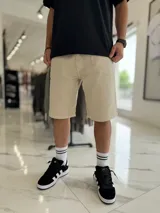Bermuda baggy de jean color beige, de corte holgado y diseño clásico de cinco bolsillos.