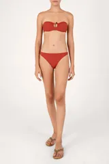 Top de bikini bandeau con abertura circular central, argolla decorativa, fruncido frontal y tirantes removibles.