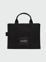 Bolso tote de lona color verde oliva con estampado frontal en blanco que dice 'THE TOTE BAG MARC JACOBS'. Cuenta con doble asa superior, correa de hombro ajustable y extraíble en color negro, y cierre superior con cremallera.
