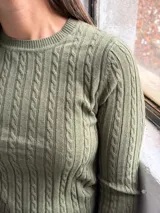 Sweater de punto con diseño de trenzas verticales, cuello redondo y mangas largas, en color verde oliva.