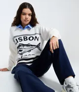 Suéter de punto color blanco con escote en V, manga larga y diseño holgado. Presenta un estampado frontal en color negro con el texto 'LISBON PORT' y un dibujo de un pez, además de detalles de rayas horizontales en el ruedo.