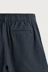 Bermuda de corte regular fit confeccionada en tejido mezcla de algodón y lino. Presenta cierre frontal con cremallera y botón, bolsillos laterales y bolsillos traseros de vivo.