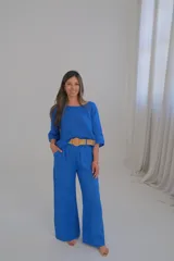 Pantalón de lino azul francia, de corte recto y tiro medio, con cinturón beige de soga incluido.