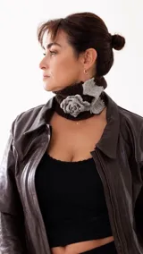 Cuello tejido a mano en lana merino, de color marrón chocolate, con detalle de flor tejida en color gris.