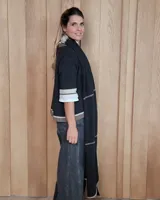 Bufandón de lana lambswool, de textura suave y liviana, con diseño liso y etiqueta de cuero en el extremo inferior.