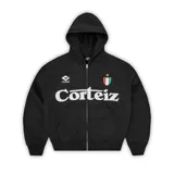 Campera con capucha y cierre frontal, color negro, con estampado gráfico frontal que incluye el logo de la marca y un escudo estilo deportivo.