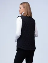 Chaleco negro capitoneado con cuello con solapa, abertura central con botones y bolsillos delanteros.
