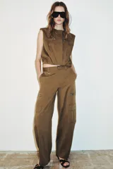 Pantalón de tiro alto con diseño tipo cargo, pernera holgada que se estrecha hacia el tobillo, bolsillos laterales con cierre y bolsillos de plastrón con solapa.