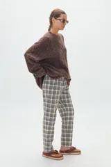 Pantalón de corte recto y tiro alto en tejido twill, con patrón de cuadros pequeños en tonos neutros. Cuenta con bolsillos laterales y presillas para cinturón.