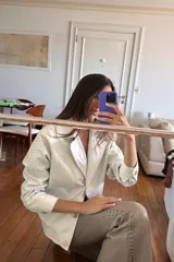 Pantalón Oxford de cuero ovino color visón con pasamanería a tono en los tajos laterales. Cierre frontal con cremallera.