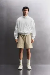 Short jogger marrón de corte relaxed fit, confeccionado en tejido compacto de algodón, con cintura elástica ajustable, bolsillos frontales en la cadera y bolsillo trasero de plastrón.