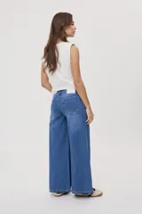 Jean wide leg de tiro medio, con pierna amplia de caída recta, diseño de cinco bolsillos, pasacintos y cierre frontal con botón y cremallera.