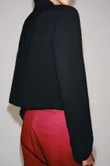Blazer negro ZW Collection con cuello perkins, manga larga con vuelta en los puños y bajo asimétrico. Presenta detalles de alamares bordados en el frente.