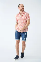 Camisa de manga corta con estampado botánico de hojas en tonos azul y blanco. Presenta cuello clásico, cierre frontal abotonado y corte slim.