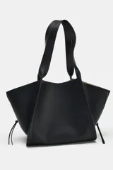 Bolso de hombro maxi shopper negro, con detalle de cremalleras en los laterales, doble asa de hombro y cierre con botón imantado.