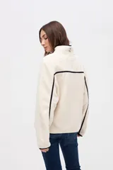 Campera de sherpa doble faz color bordó, con cierre frontal de botones, cuello alto y bolsillos laterales. Presenta detalles de vivos en nylon color tostado en los bordes y costuras.