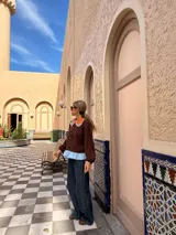 Camisa de manga larga en color marrón chocolate, con cuello redondo estilo Peter Pan en color naranja con borde a cuadros y detalle de volado en el ruedo en color celeste.