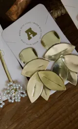 Aros colgantes dorados con forma de hojas.