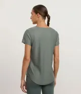 Remera deportiva de microfibra en color verde grisáceo, con cuello redondo, mangas cortas y detalle de estampa lateral con ondas en tonos contrastantes.