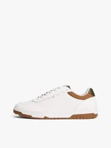 Zapatillas de corte bajo estilo retro baloncesto, confeccionadas en piel blanca con paneles de textura a contraste en color marrón y verde oliva en el talón. Presentan suela de goma dentada, cierre con cordones y logo de Tommy Hilfiger en el lateral y la lengüeta.