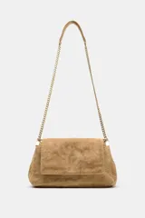 Bolso de hombro de piel color tostado con diseño acolchado y costuras geométricas. Cuenta con tres compartimentos, uno de ellos con cierre de cremallera, y solapa con cierre magnético. Incluye asa combinada de piel y cadena metálica dorada.