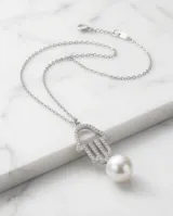 Collar de plata con cadena fina y dije en forma de mano de Hamsa decorado con circonias, acompañado por un dije de perla de río colgante.