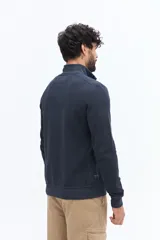 Buzo de algodón color azul marino con medio cierre frontal y cuello alto. Presenta un pequeño logo bordado en el pecho.