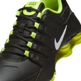 Championes Nike Shox NZ, de color negro con detalles en verde lima y el swoosh en blanco. Cuentan con sistema de amortiguación Shox en el talón y pasadores en la zona del empeine.