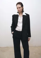 Pantalón de jean estilo wideleg color negro, con tiro medio, cierre frontal de cremallera y botón, trabillas para cinturón, bolsillos laterales y detalle de pinzas delanteras.