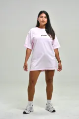Remera oversize color rosado, con cuello redondo, mangas cortas y estampa frontal con la frase "NO BASIC" en negro.