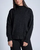 Sweater de punto color beige, con cuello alto y diseño de ochos en diagonal en los laterales. Presenta mangas largas con puños acanalados y un corte holgado.