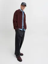 Pantalón gris oscuro de corte holgado, con pinzas en la cintura y estilo relaxed.