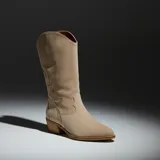 Bota texana de caña alta con diseño clásico, confeccionada en gamuza color beige, con taco cuadrado y punta fina.