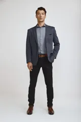 Blazer de corte clásico color azul oscuro, con cierre frontal de un botón, solapas de muesca y bolsillos laterales con solapa. Presenta un bolsillo superior con pañuelo decorativo y puños con botones.