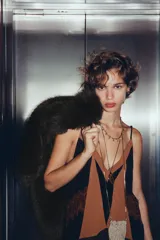 Vestido corto con tirantes finos ajustables, escote en V profundo con paneles en color negro y marrón. Presenta detalles de encaje marrón en el torso y un bajo con volantes de tul negro y encaje festoneado.