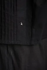Blusa de algodón peinado color negro, con tirantes finos, escote en V y detalles de bordados y encaje en el frente.