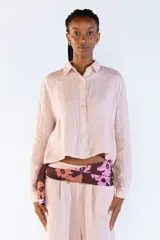 Camisa de lino 100% italiano, color rosado, de corte cropped, manga larga y cierre frontal con botones.