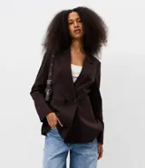 Blazer de sastrería marrón oscuro de corte ajustado, con solapa clásica, bolsillos con solapa en los laterales y cierre frontal cruzado con dos botones.