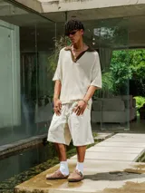 Chomba de tejido de punto abierto color crudo con cuello polo en color marrón chocolate.