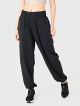 Pantalon de buzo negro de corte holgado, con cintura elástica, puños ajustados en los tobillos y bolsillos tipo cargo laterales.