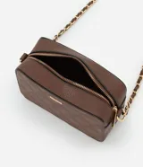 Cartera bandolera pequeña de textura granulada, con cierre superior de cremallera y correa de cadena entrelazada con material sintético. Presenta un diseño rectangular con placa metálica decorativa en el frente.