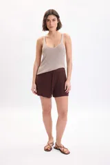 Musculosa de punto con hilo lurex en color beige, de corte ajustado al cuerpo, con escote en V y tirantes finos.