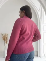 Sweater fucsia de punto con cuello alto y estampado de siluetas de gatos en el frente.