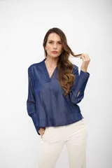 Blusa de tela tipo denim en color azul noche, con escote en V y mangas largas con puños anchos abotonados.