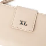 Billetera color taupe de símil cuero con solapa y cierre. Presenta un logo metálico "XL" en la solapa y una correa de muñeca desmontable.