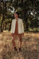 Campera de cuero color crema, con cierre frontal y cuello solapa.